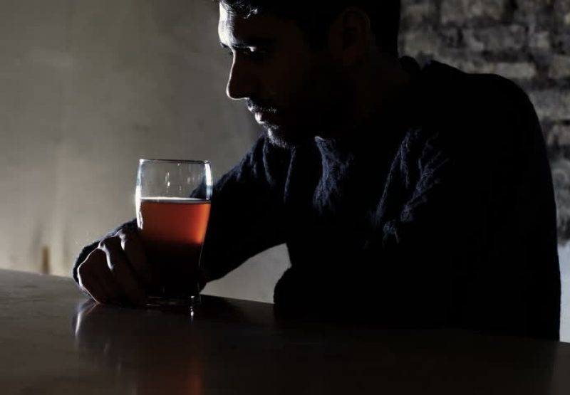 A depressed man drinking alcohol
